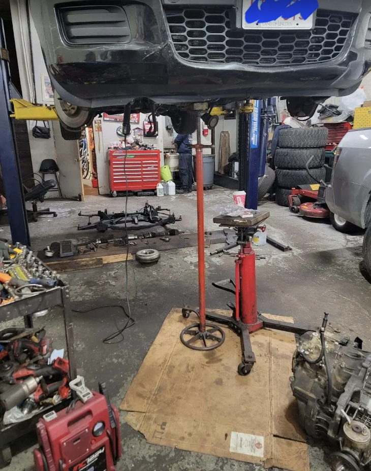 Vehicle on hydraulic lift undergoing inspection